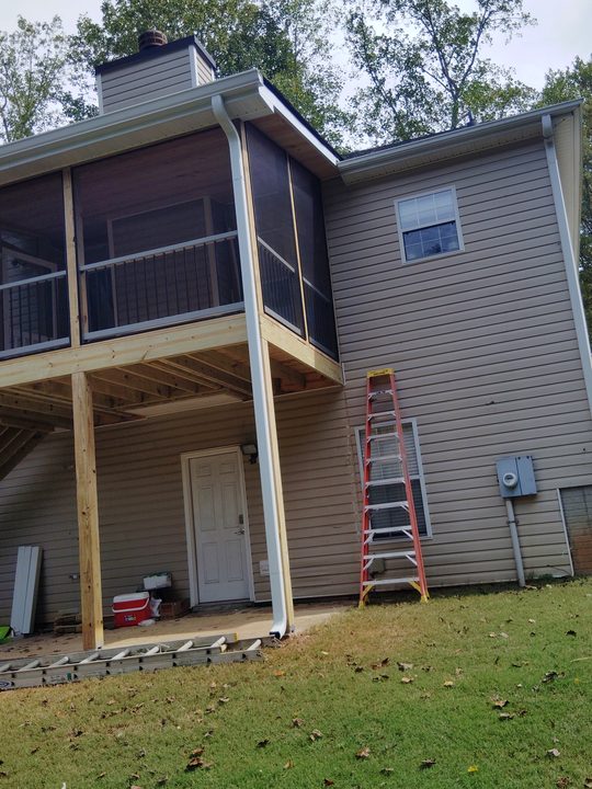 White downspout running down the post of a new screened deck